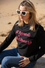 Femme portant de face le sweat noir Amore è Libertà rose paillettes, coupe moderne, décontratée et confortable