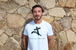 Homme portant T-shirt blanc floqué en noir de la croix et du pistolet en hommage au Circinellu