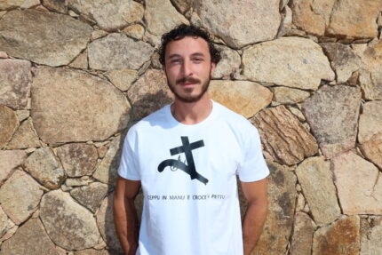 Homme portant T-shirt blanc floqué en noir de la croix et du pistolet en hommage au Circinellu