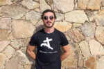 Homme portant T-shirt noir floqué en blanc de la croix et du pistolet en hommage au Circinellu