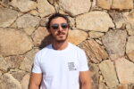 Homme portant le T-shirt blanc brodé niveau la poche gauche en noir : Terra, lingua, cultura, popolu, nazione