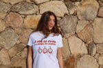 Femme portant T-shirt blanc femme "A vita hè corta è u tempu ùn aspetta", vivre pleinement chaque instant, floqué d'horloges moles en cuivre à paillettes