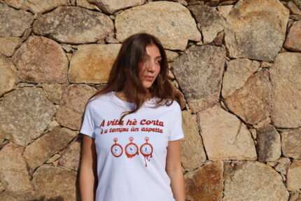 Femme portant T-shirt blanc femme "A vita hè corta è u tempu ùn aspetta", vivre pleinement chaque instant, floqué d'horloges moles en cuivre à paillettes