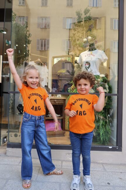T-shirt enfant orange Autonomia ARC unisexe porté par un garçon et une fille – L’Oru Corse