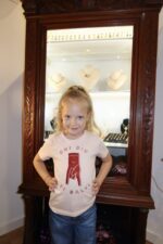 Fillette portant T-shirt rose clair E corne en rouge paillettes, col rond, coupe ajustée