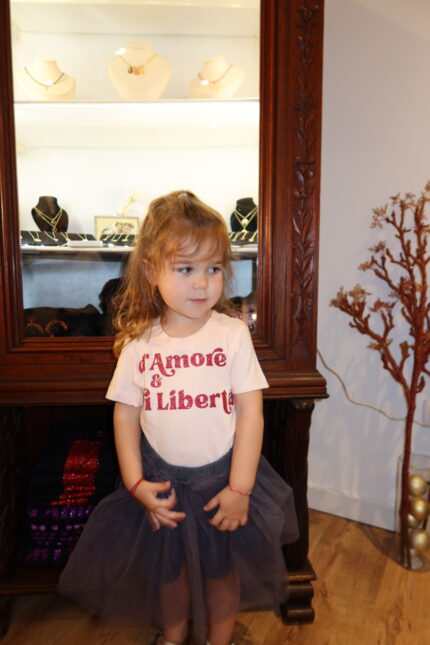 Fillette portant T-shirt rose clair col rond Amore è Libertà rose paillettes