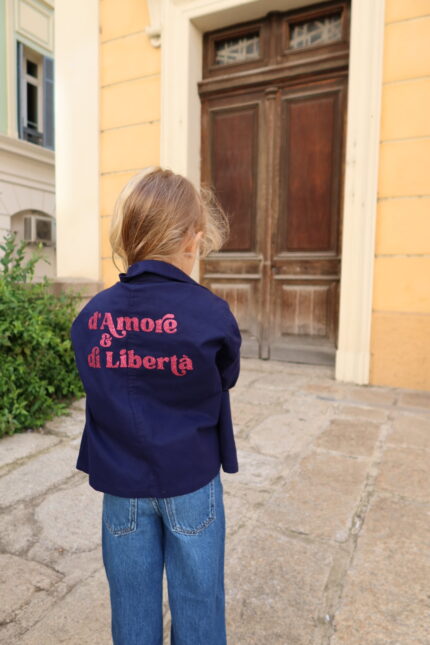 Fille portant Bleu de Chine Amore e Libertà rose à paillettes vu de dos