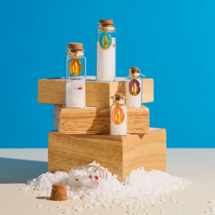 Ensemble de fioles grand format en verre, contenant du gros sel purificateur, un morceau de corail naturel et un œil de Sainte Lucie, symbole de protection et de chance en Corse, orné de médailles miraculeuses de différents choix de couleurs