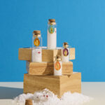 Ensemble de fioles grand format en verre, contenant du gros sel purificateur, un morceau de corail naturel et un œil de Sainte Lucie, symbole de protection et de chance.