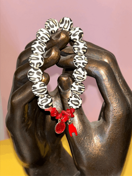 Bracelet en perles silicone motif léopard avec fragments de corail rouge, médaille miraculeuse rouge et corne protectrice, inspiré des traditions corses.