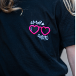 T-shirt Amore subitu noir brodé, zoom sur le motif lunette en forme de cœur et message humouristique