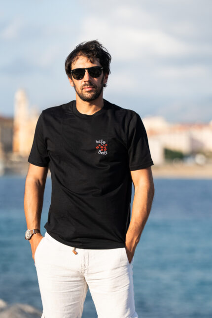 Homme portant le tee-shirt brodé Basgi Basgien pied, broderie bisous rouges visible sur le cœur, style décontracté et expressif