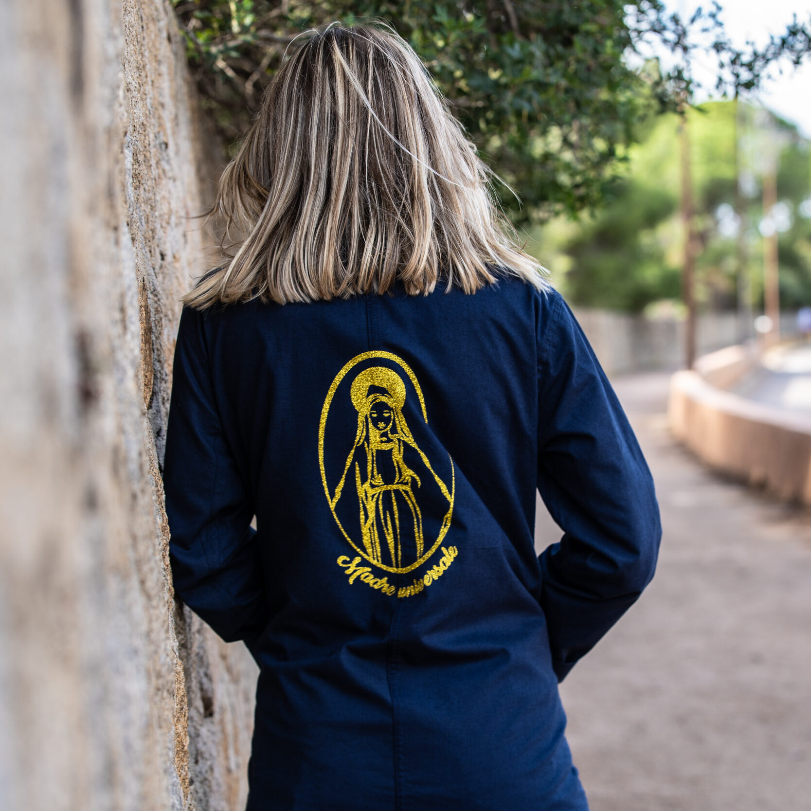 Vue rapprochée de la veste Madre Universale portée, mettant en valeur les paillettes dorées de la Vierge