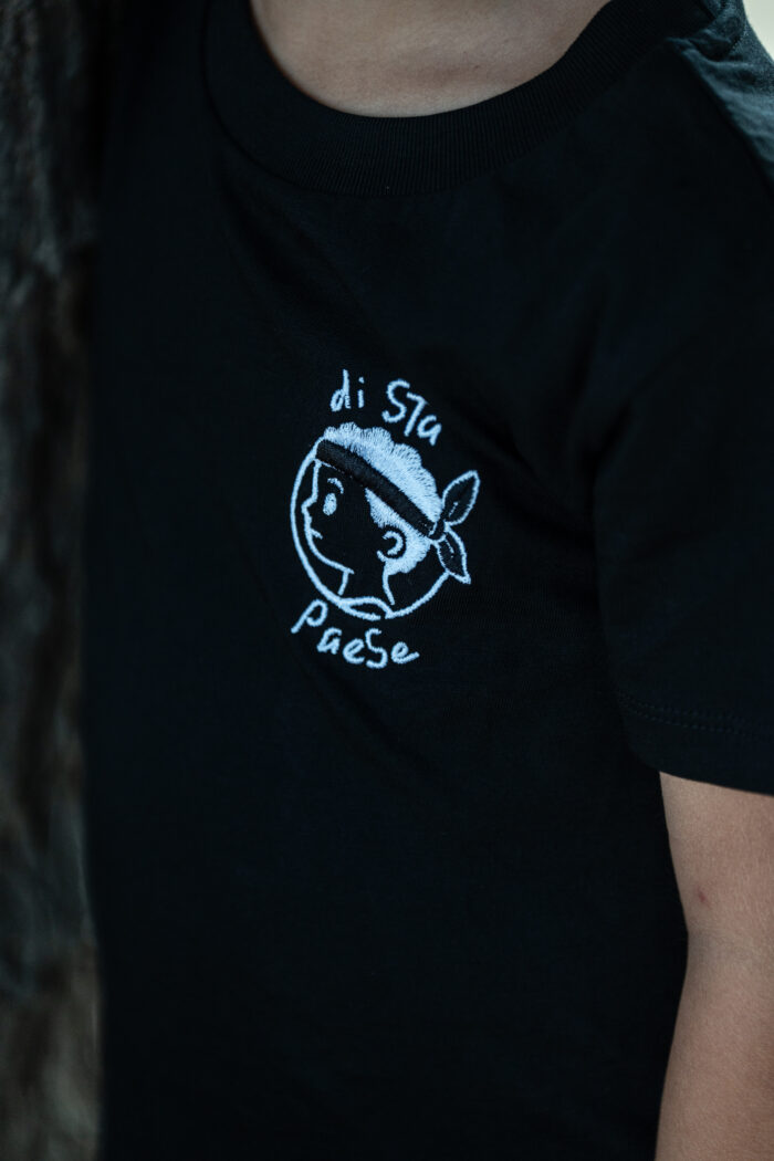 Broderie fine du message Di stu paese, personnage enfantin corse avec bandera