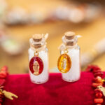 Ensemble de fioles de sel en verre avec médaille miraculeuse, bouchon en liège et sel purificateur, symboles de protection et de spiritualité.