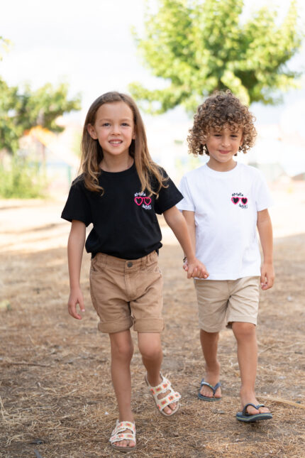 Enfants portant les tee-shirt sbrodés Amore Subitu noir et blanc, message humoristique avec lunettes en forme de cœur, coupe unisexe, t-shirt blanc en coton