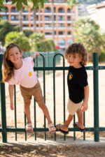 Enfants jouant en pied portant un tee-shirt brodé Capu ind’e stelle, message poétique et étoile jaune, disponible en noir, blanc, bleu et rose