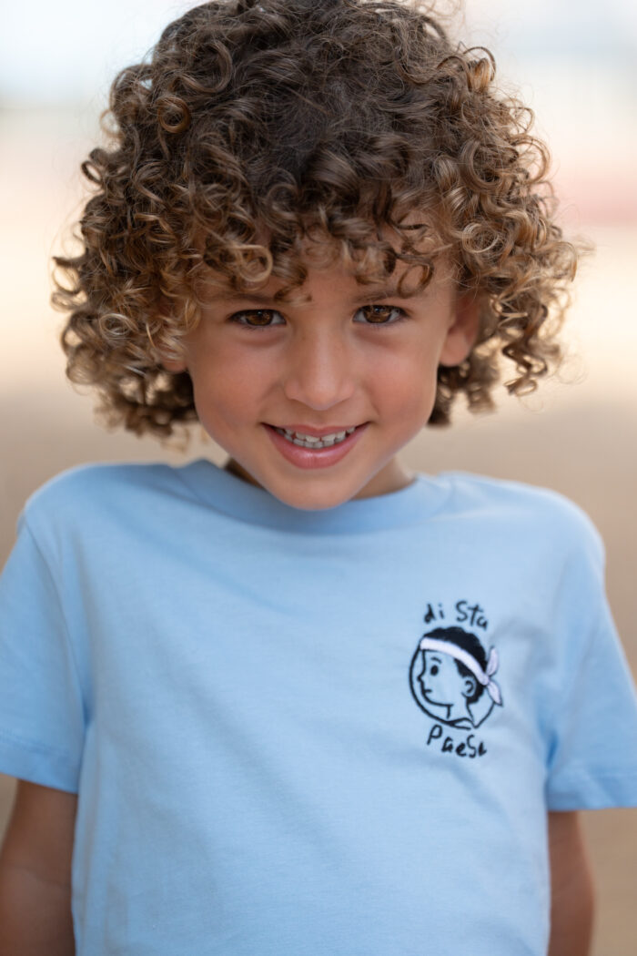 Garçon portant le T-shirt bleu brodé Di stu paese, motif personnage corse avec bandera, coton doux et coupe unisexe