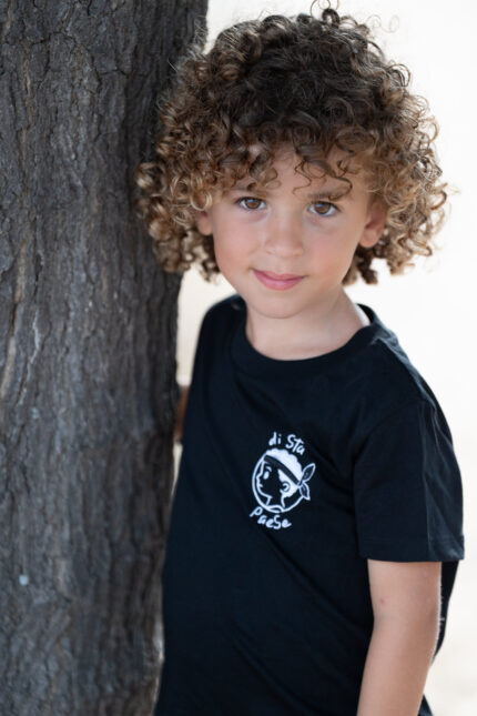 Garçon portant le T-shirt noir brodé Di stu paese, motif personnage corse avec bandera, coton doux et coupe unisexe