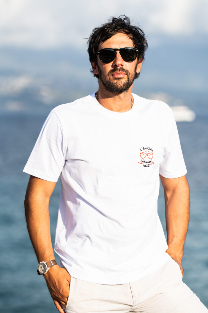 Homme portant le tee-shirt brodé Amicizia blanc de buste, message brodé visible sur le cœur, style simple et convivial