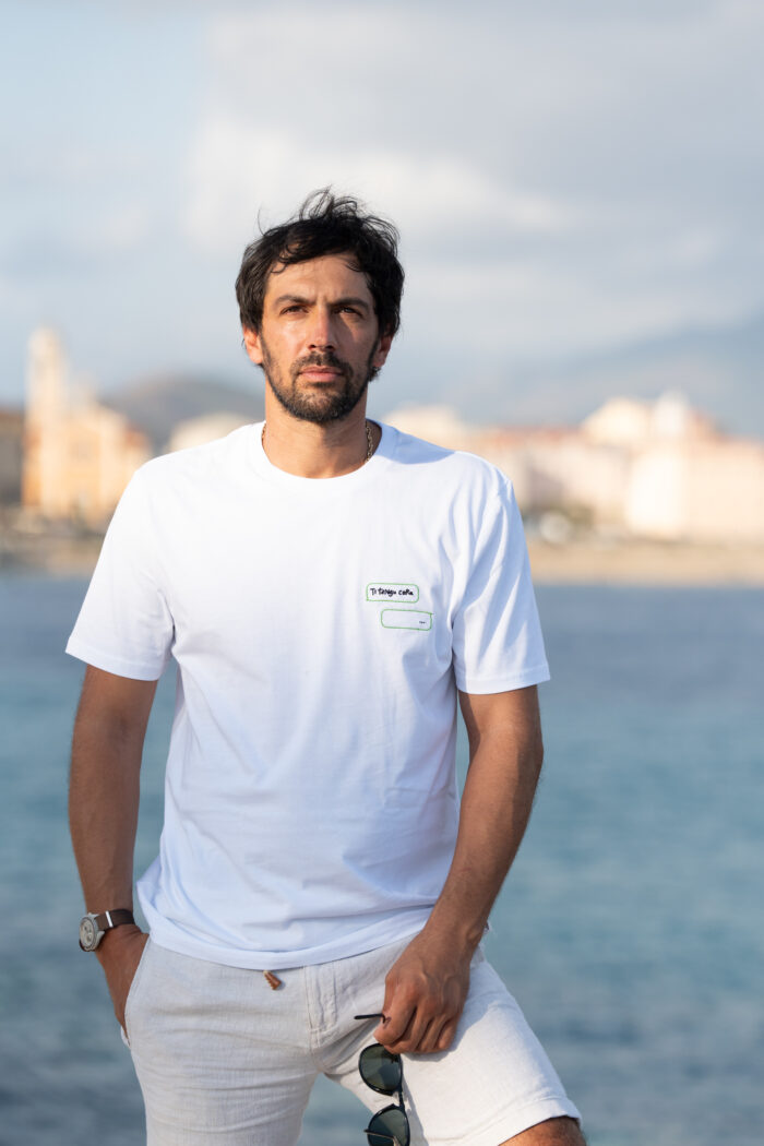 Homme portant le tee-shirt brodé blanc Ti tengu caru, vue en buste, broderie façon message visible sur la poitrine