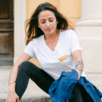Femme porte le t-shirt blanc avec les détail broderie orange Cool Mamma Club côté gauche t-shirt femme – L'Oru Ajaccio