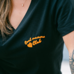 Détail broderie orange Cool Mamma Club côté gauche t-shirt noir femme – L'Oru Ajaccio