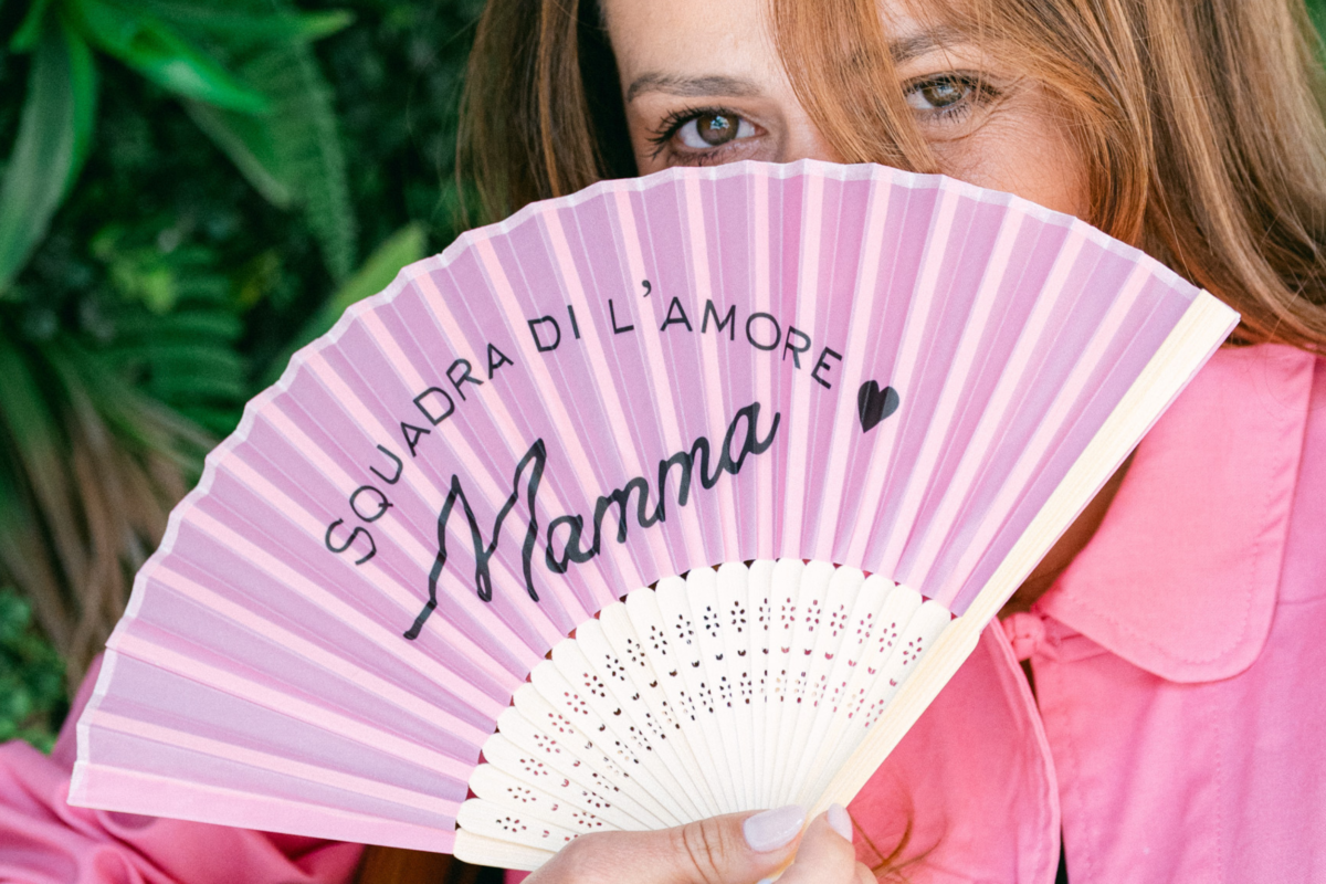 Femme au regard espiègle tenant un éventail rose "Mamma squadra di l'Amore"